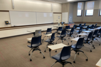 Front of room view with lectern on right in front of markerboard 