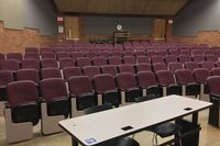 Back of room view of student auditorium seating and exit doors at rear of room