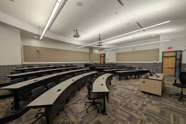 Back of room view of student tiered fixed-table and chair seating 
