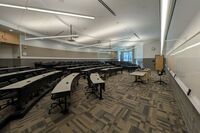 Back of room view of student tiered fixed-table and chair seating 