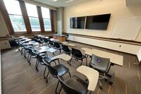 Front of room view with lectern on left in front of display and wall mounted camera