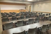 Photo of front of room from back of room, student table and chair seating  