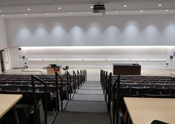 Front of room view with lectern on left side and demonstration bench on right side