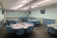 View of room showing of student group table and chair seating, markerboards, and display monitors on walls