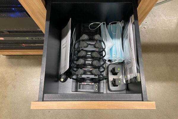 Pedestal - inside view of drawer showing assistive listening devices in charger