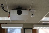 Camera mounted to the ceiling and instructor enabled adjustments to the lens to allow the instructor to be "seen" by the camera in more locations around the room