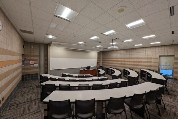 Front of room view with lectern on center in front of markerboard