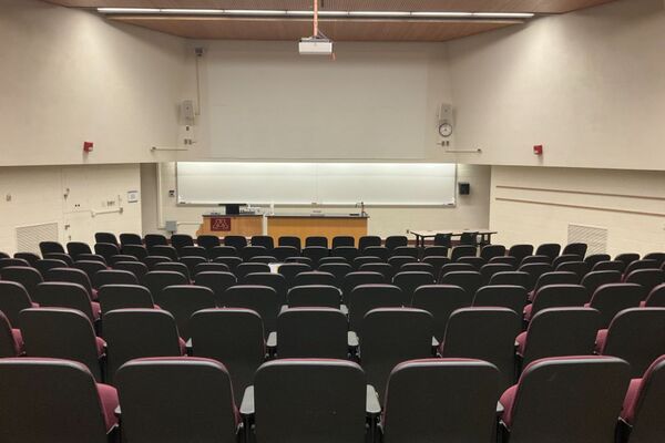 Front of room view with lectern on left and demonstration bench center in front of markerboard