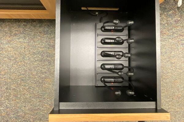 Pedestal - inside view of drawer showing assisted listening devices in charging base