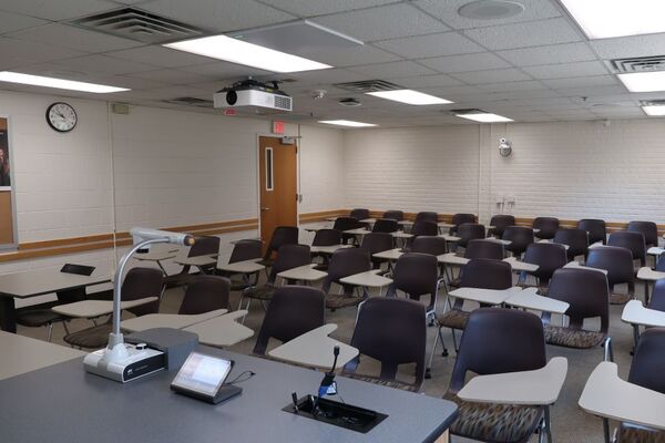 Back of room view of student tablet arm seating and exit door on left