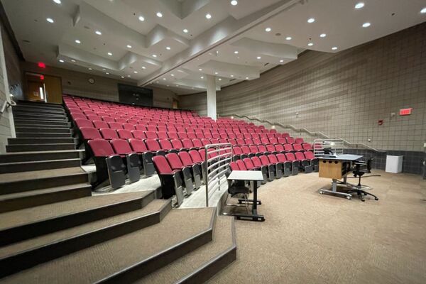 Back of room view of student auditorium seating and double exit doors at rear of room